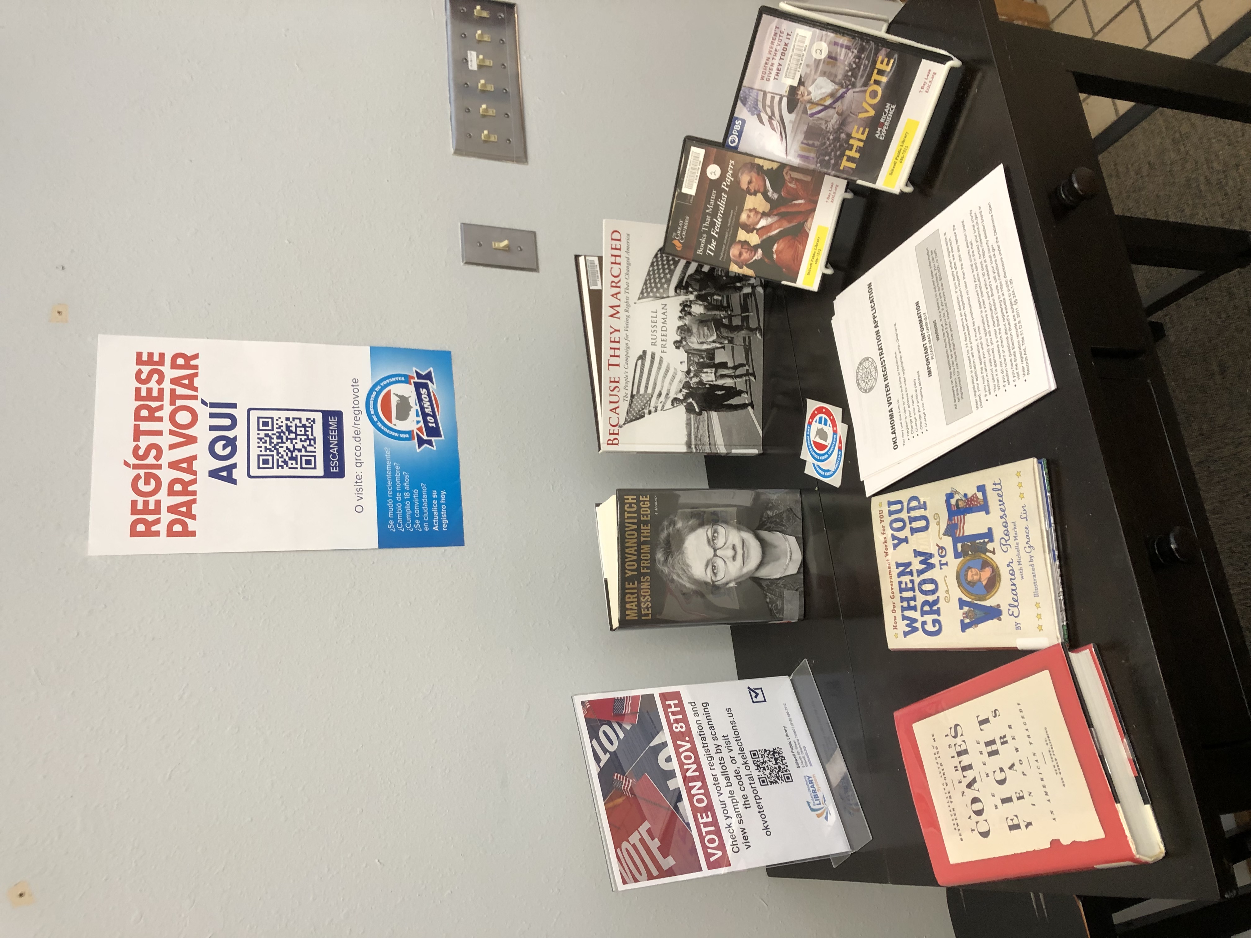 Voter registration book display at Stilwell Public Library with Spanish language sign